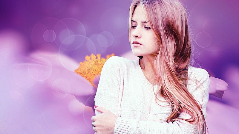 Frau vor violettem Hintergrund und weßer Blüte