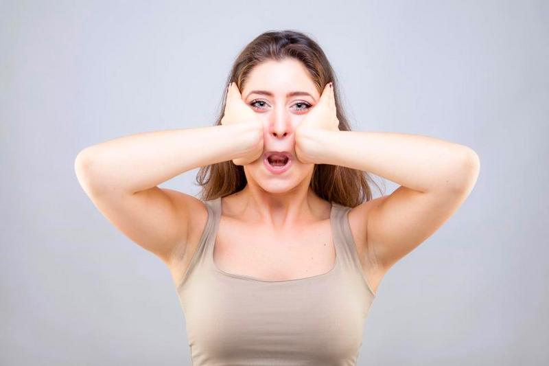 Gesicht Yoga Trend - Frau massiert Gesichtsmuskulatur mit den Händen