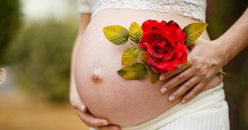 Babybauch mit Rosen geschmückt
