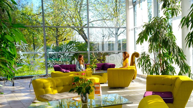Eingangsbereich Seminarhaus mit Sofas und Menschen