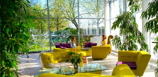 Eingangsbereich Seminarhaus mit Sofas und Menschen