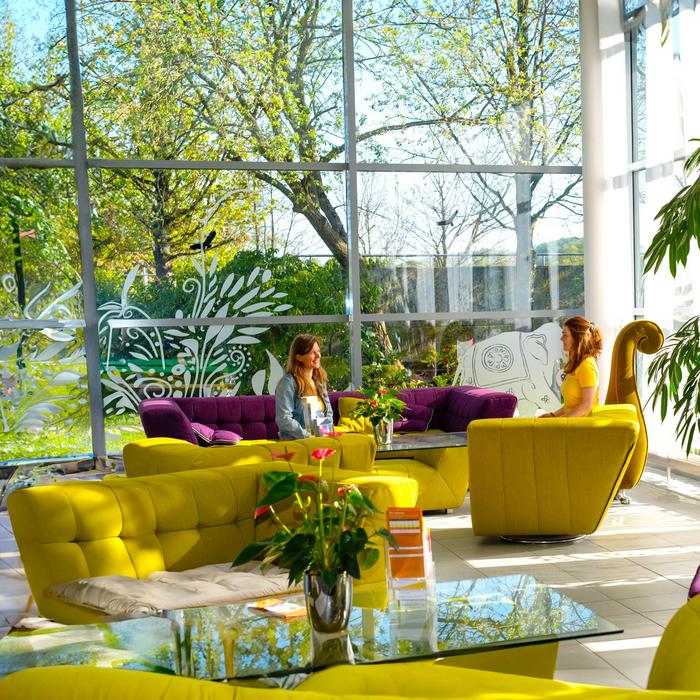 Eingangsbereich Seminarhaus mit Sofas und Menschen