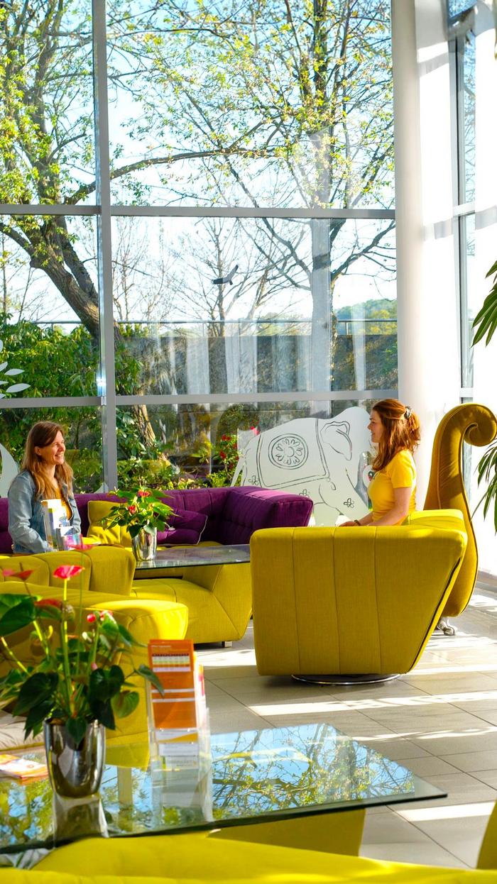 Eingangsbereich Seminarhaus mit Sofas und Menschen