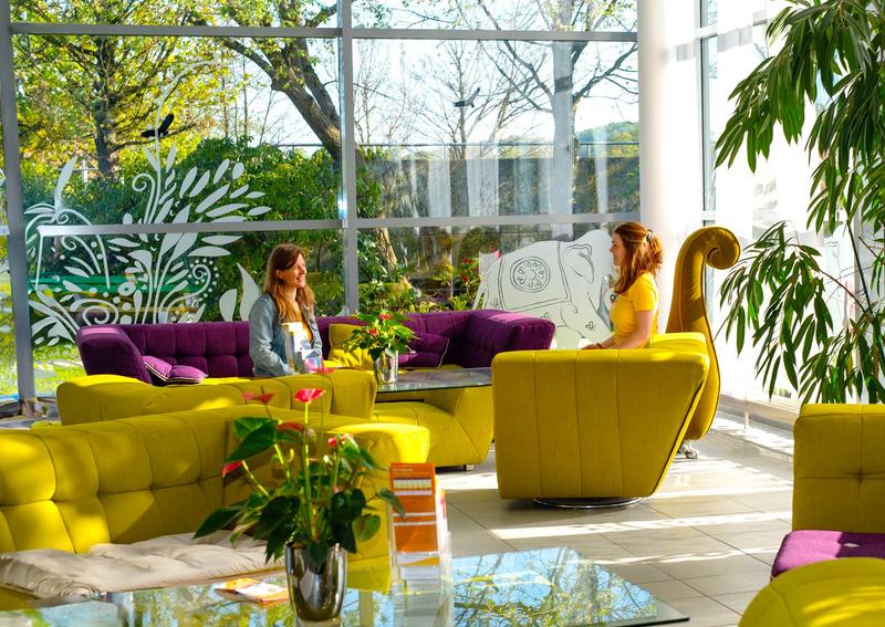 Eingangsbereich Seminarhaus mit Sofas und Menschen