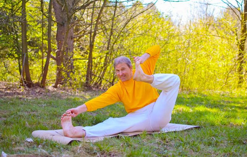 Yogi übt Akarna Dhanurasana in der Natur während einer Yoga Intensivpraxis