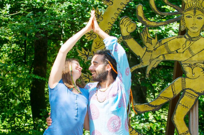 Yoga und Meditation Einführung bei Yoga Vidya Zwei Menschen stehen sich lächelnd gegenüber und heben die Arme in einer offenen, verbundenen Geste