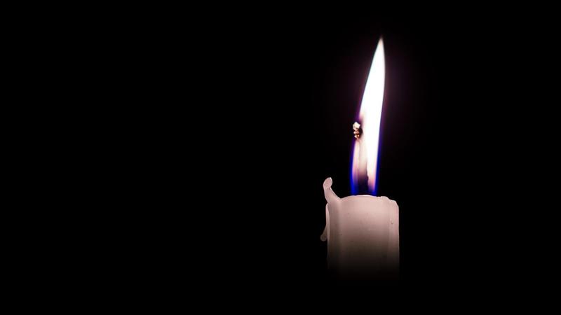 Weiße Kerze in der Dunkelheit