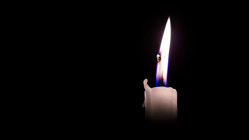 Weiße Kerze in der Dunkelheit