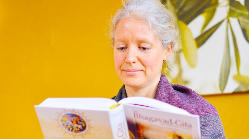 Frau liest aus der Bhagavad Gita