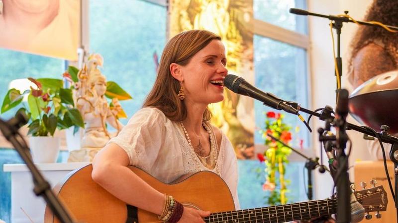 Frau spielt Gitarre und singt