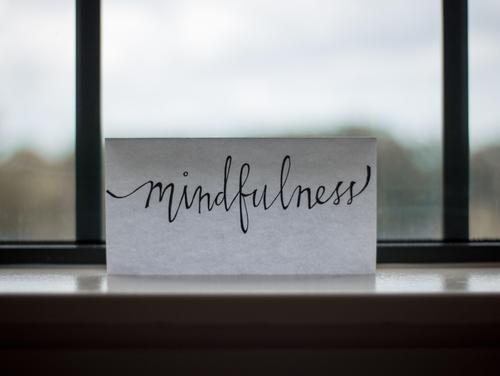 Zettel mit dem Wort mindfulness am Fenster klebend