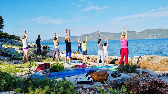 Gruppe praktiziert Yoga am Meer in Kroatien