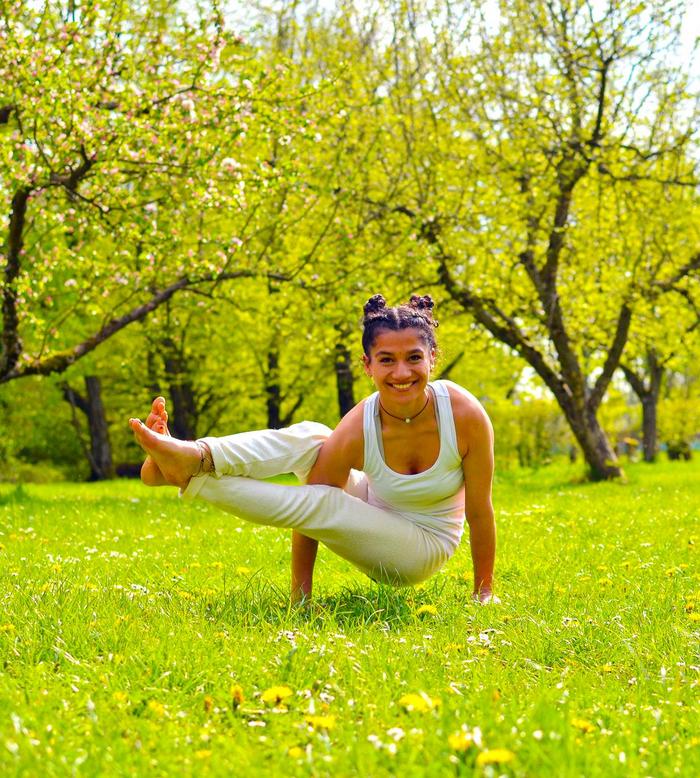 Frau praktiziert die Seitkrähe als Yoga-Übung im Park.