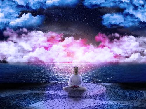 Ein Mann sitzt am Meer und meditiert, hinter ihm sind kosmisch gefärbte Wolken in blau, weiß und pink