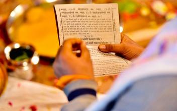 Nahaufnahme von Händen, die traditionelle Sanskrit-Schriften halten