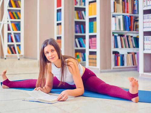 Yoga Bücher Online lesen Frau in Yogaposition liest ein Buch