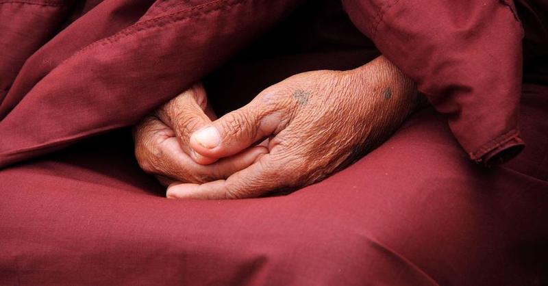 Hände im Schoss eines Mönchs